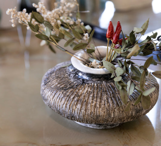 Vaso tondo e basso scolpito